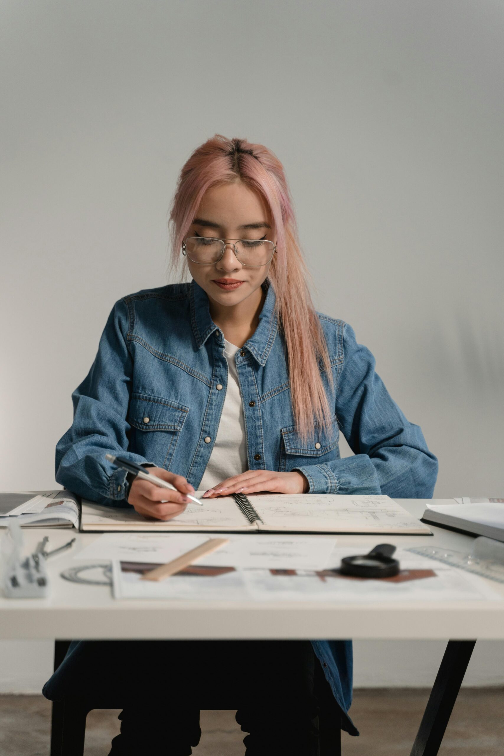 Young woman architect working on blueprints at her desk.